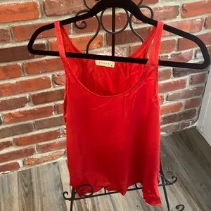 Sleeveless red blouse.